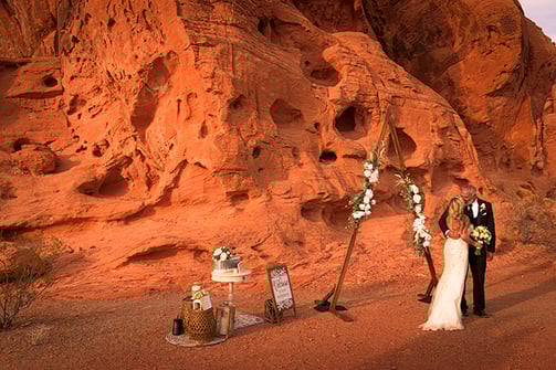 a man and woman standing in front of a mountain