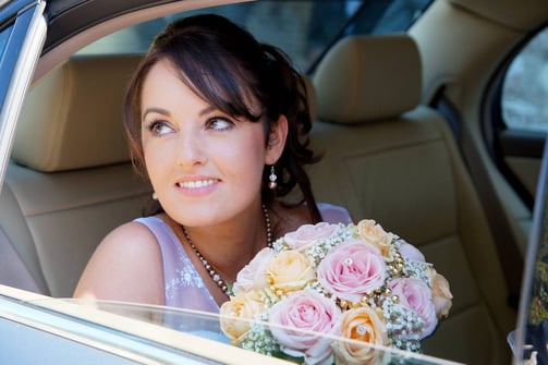 photo de mariée dans la voiture avec son bouquet