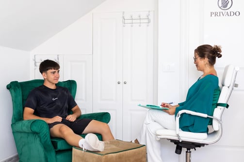 Psicoterapeuta conversando con paciente joven en sesión individual, en un entorno privado y acogedor en Tenerife, enfocado en