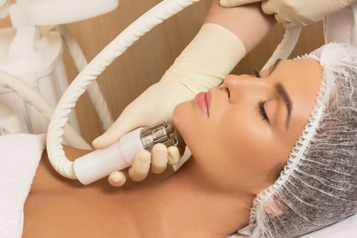 a woman is getting her facelift done by a professional hairdress