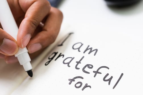 a person writing on a notepad with a pen