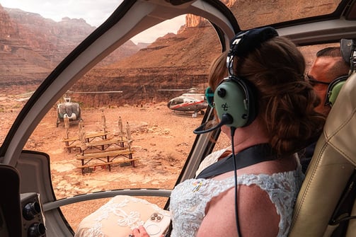 a woman in a white dress is sitting in a helicopter