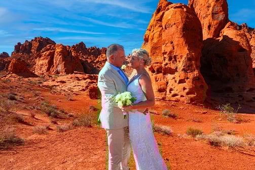 a man and woman standing in front of a mountain