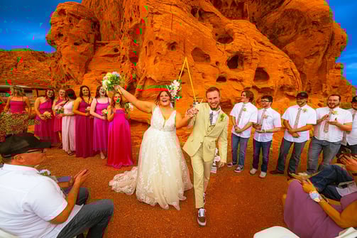 a man and woman are walking down a path in front of a mountain