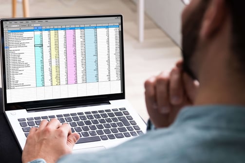 EMPRESÁRIO PREOCUPADO OLHANDO PLANILHA EM LAPTOP