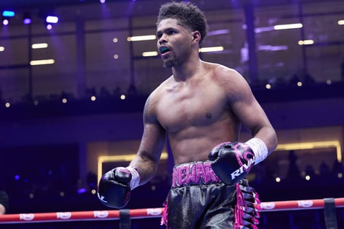Shakur Stevenson flexing in boxing ring under purple lights