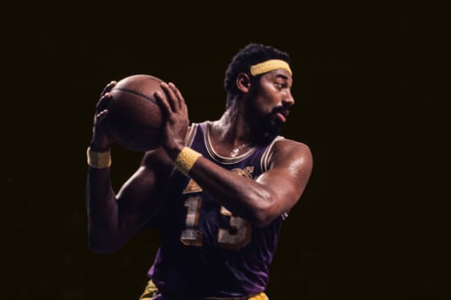 Wilt Chamberlain holding basketball, dark background