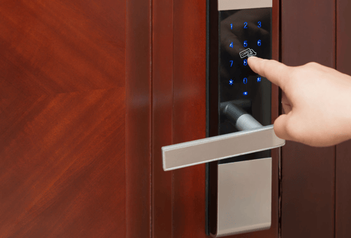 a person's hand is pressing a keypad on a door