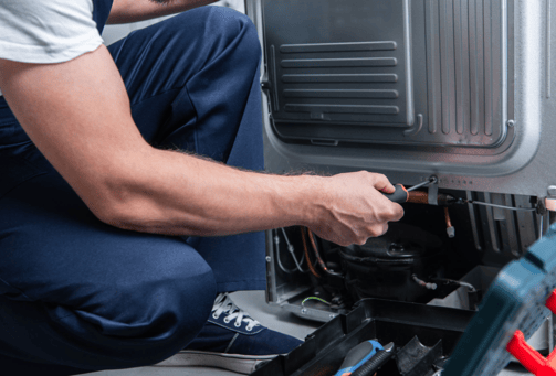 a man in a white shirt is fixing a machine