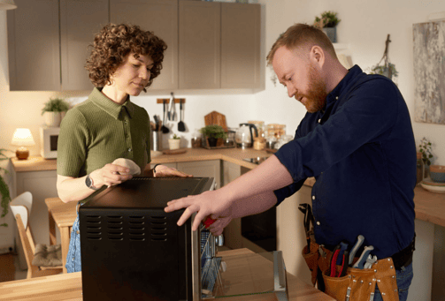 a man and woman standing in a kitchen