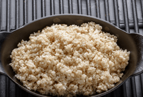 a bowl of rice with a spoon and a fork