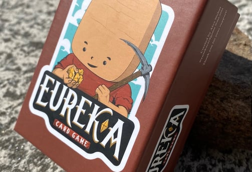Eureka the mining card game deck on a rock table