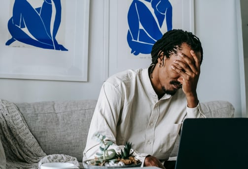a man sitting on a couch with his laptop computer
