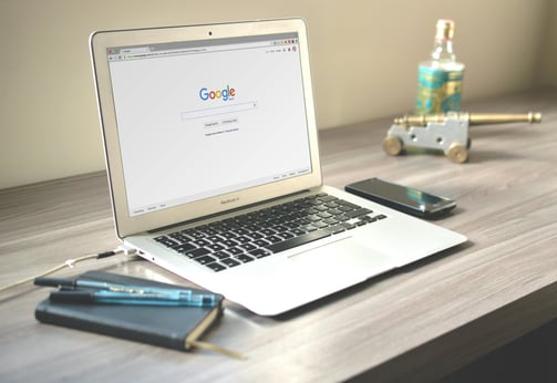 Modern workspace with a laptop open to Google search, symbolizing the importance of online visibilit