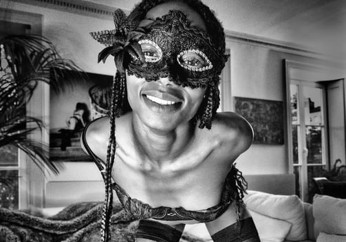 Belle jeune femme noire avec un magnifique sourire et un masque qui porte des bas 