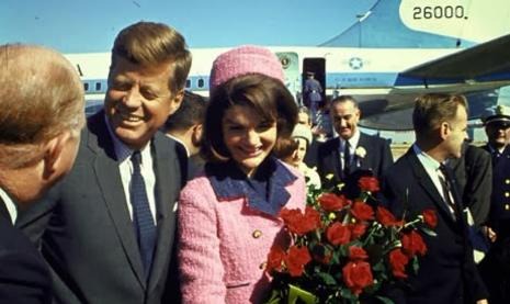 a man and woman standing in front of a plane