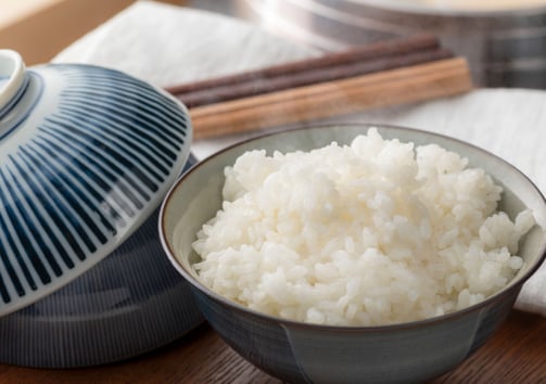 a bowl of rice with chopsticks and chopsticks