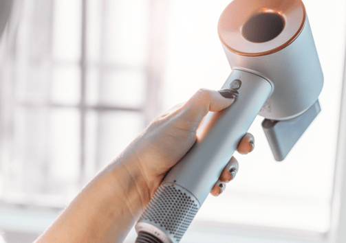 a woman is holding a hair dryer in her hand