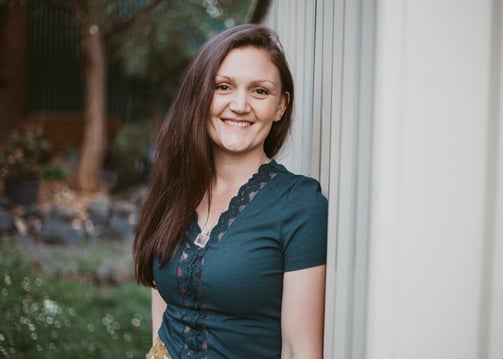 a woman in a green dress smiling and looking at the camera