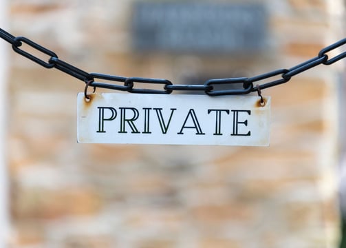 a private sign hanging from a chain link