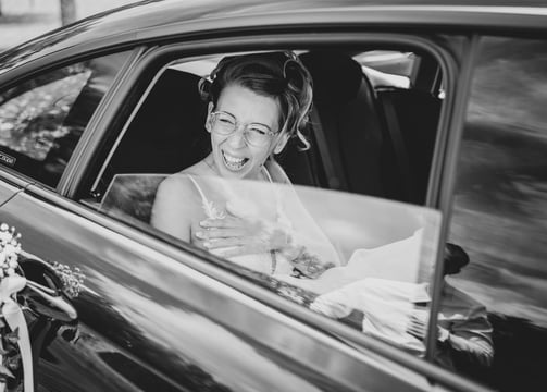 a bride laughing in a car