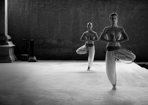 two people are doing yoga exercises on a platform