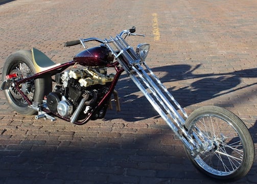 custom motorcycle parked on a brick road