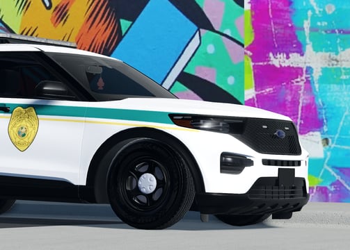 a police car parked in front of a wall with graffiti