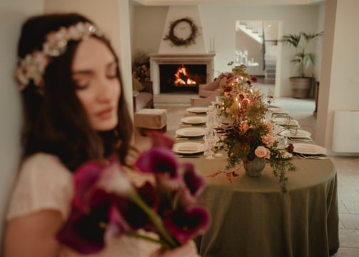 a woman in a white dress is holding a bouquet