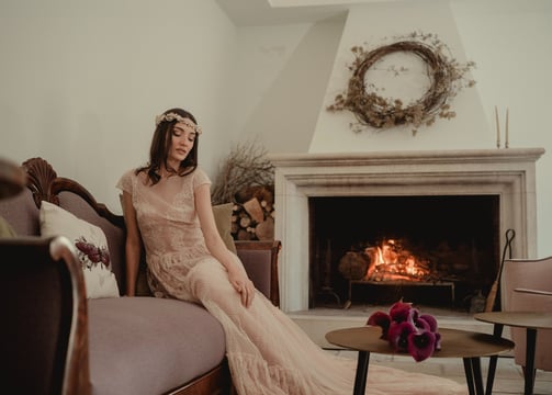 a woman in a long dress sitting on a couch