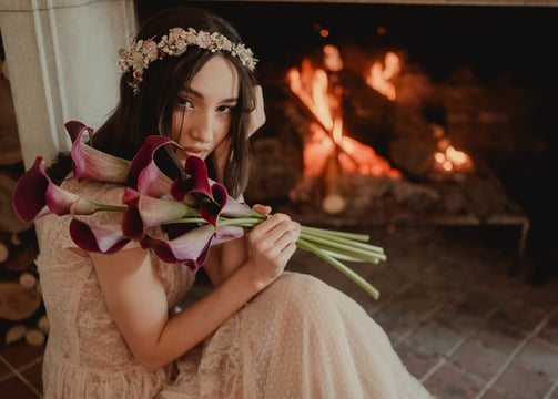 a woman in a dress with flowers in her hands