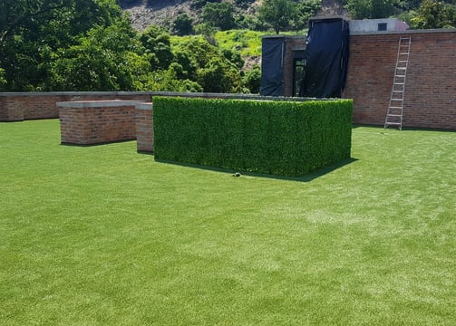 Área de juegos infantil con pasto artificial seguro y suave