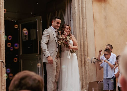 couple de jeune mariés sur les marches de l'église