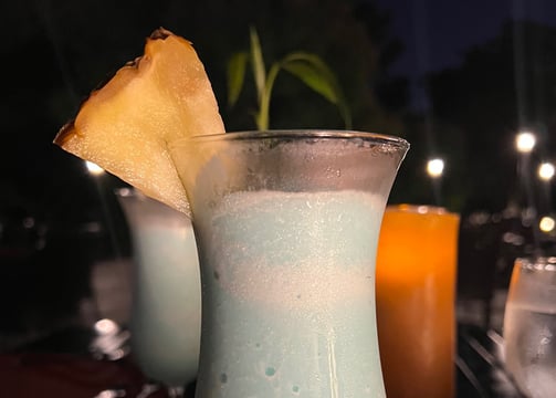 product photography of a drink in a glass with a pineapple on top