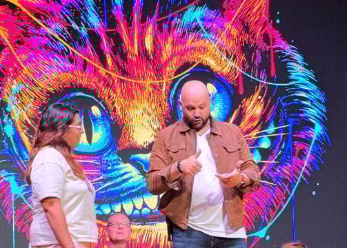 a man and woman on stage with a cat