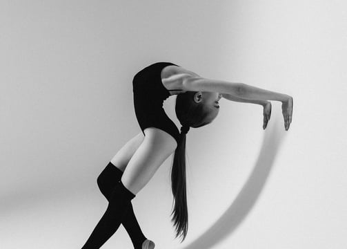 A gumnast is showing the back flexibility