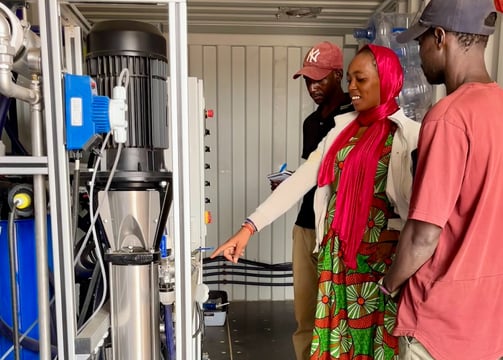 a man and woman standing in a container on a water plant