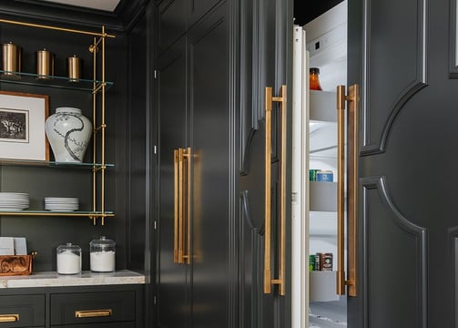 a kitchen with black cabinets and gold accents