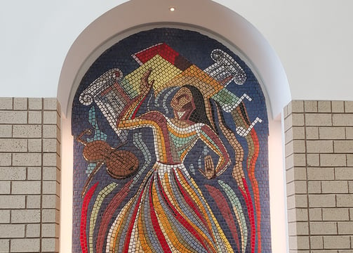 a large mosaic tile window with a large painting of a woman