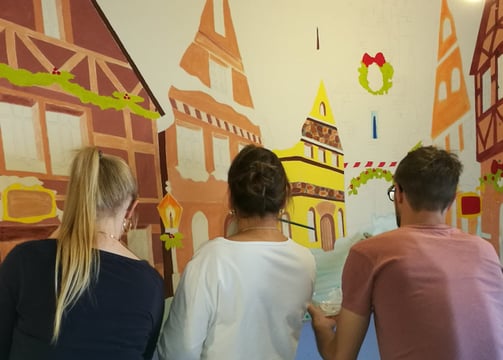 Das Team beim Malen einer Winterstadt