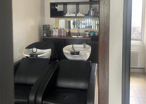 Zone de soin capillaire avec bacs de lavage professionnels chez X Tension NC, pour une expérience d