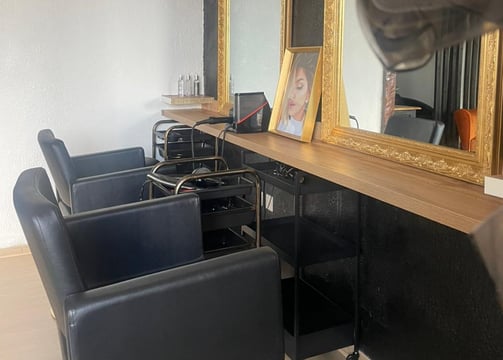 Vue intérieure du salon X Tension NC avec fauteuils professionnels et miroir doré, un espace dédié à