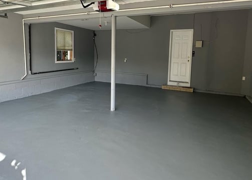 a garage with a garage door open and a garage door open