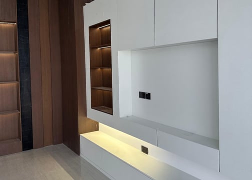 a living room with a white entertainment center and a large entertainment center