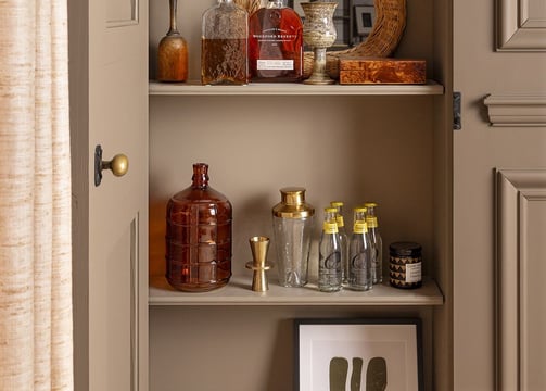 a cabinet with a shelf full of bottles and bottles