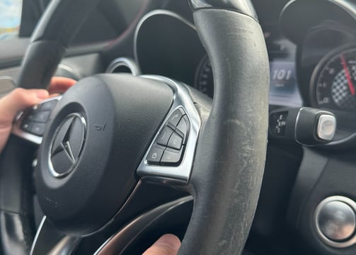 a person holding a steering wheel in a car