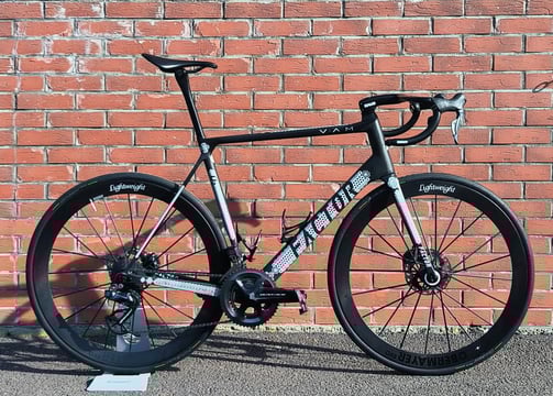 a custom Factor O2 parked on the side of a brick wall