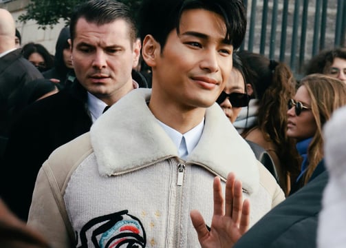 un homme qui sort de la fashion week avec deux grosses broderie sur sa veste