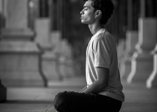 a man sitting on the ground doing meditation