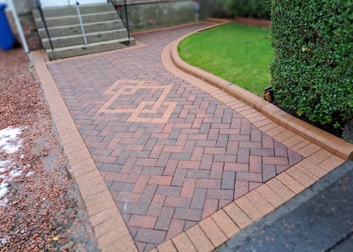 a brick path and concrete steps leading to a house